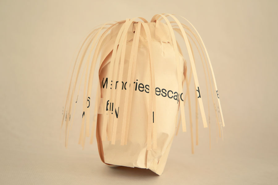 Vase made of paper with the words memories escaping spilling out of it